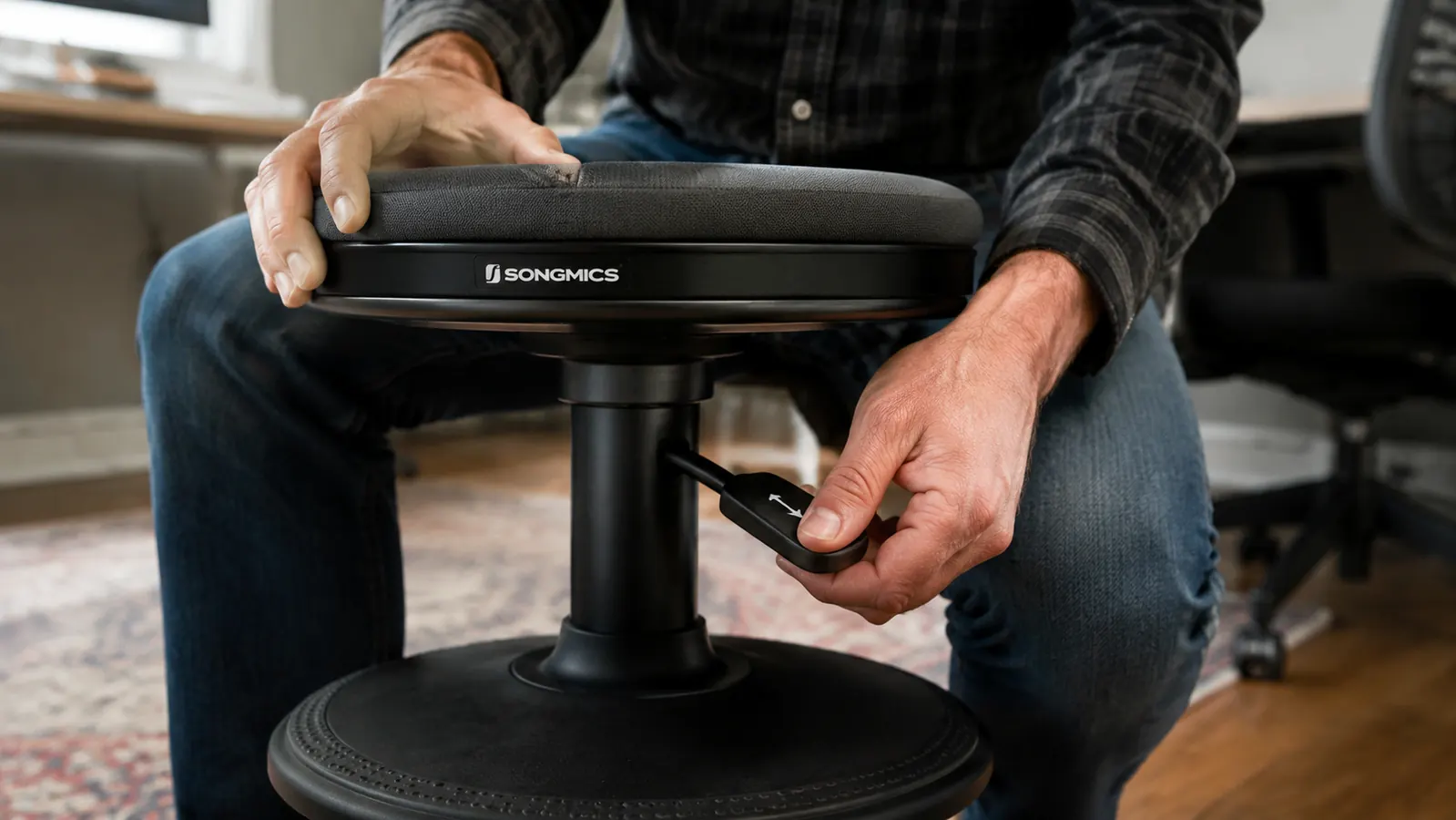 Close-up of a person's hand adjusting the height lever on the SONGMICS wobble stool base